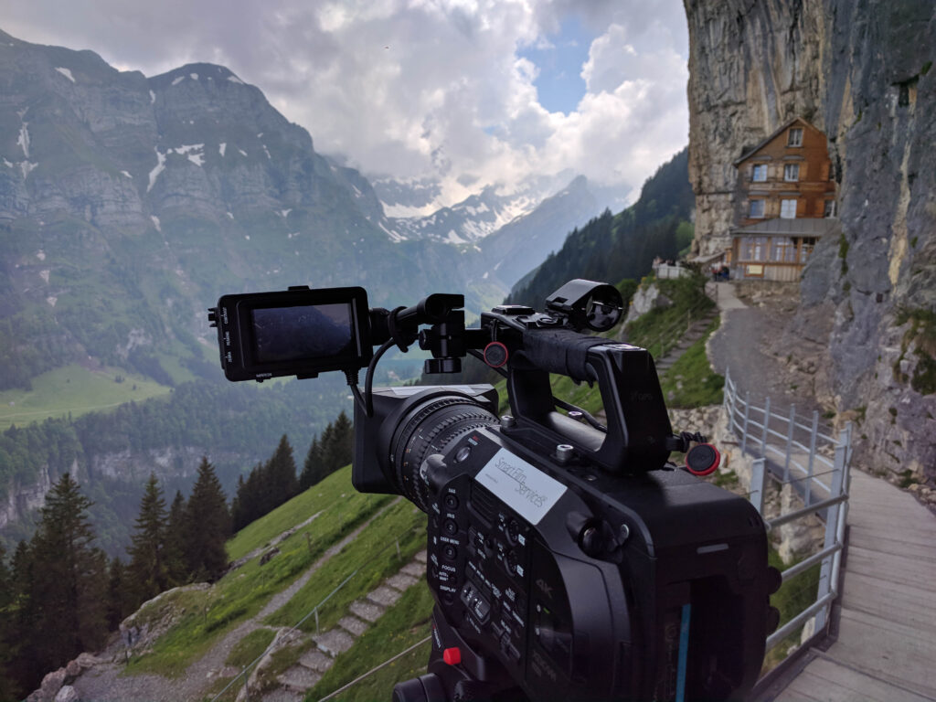 Une caméra de cinéma devant un panorama de montagne